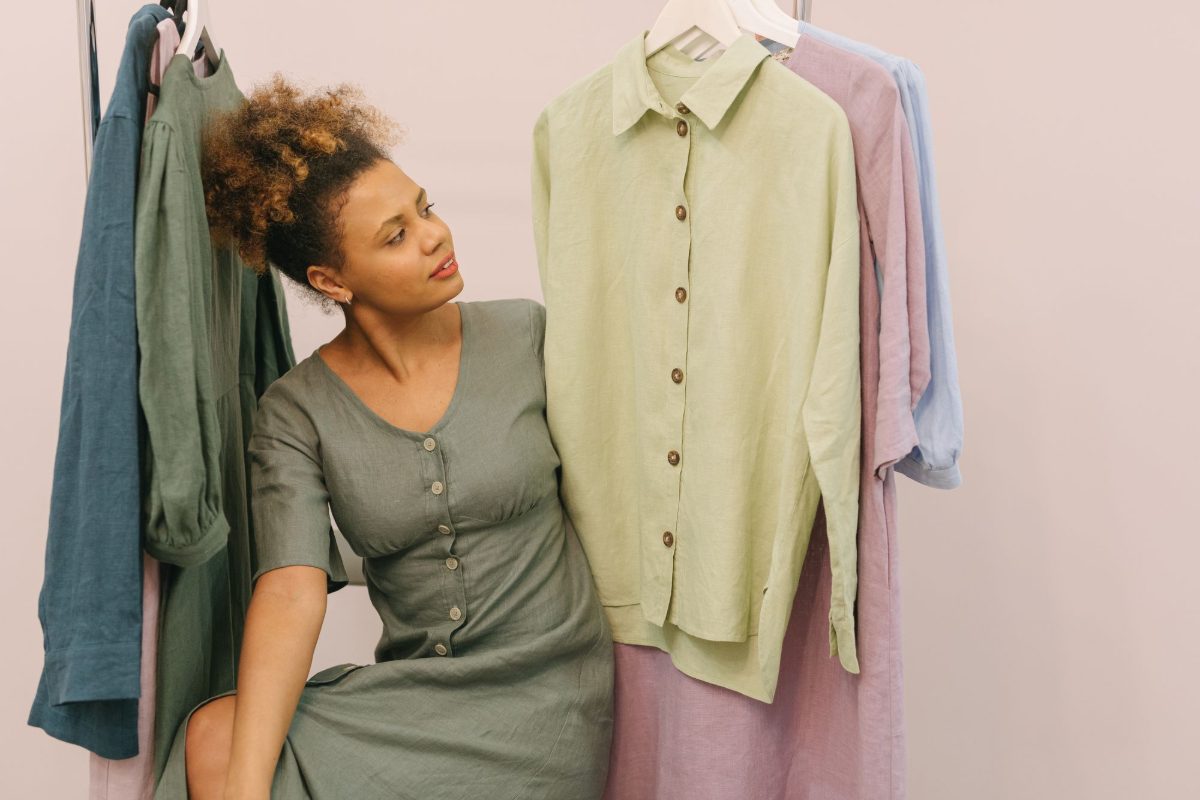 Lojista entre as araras de roupa